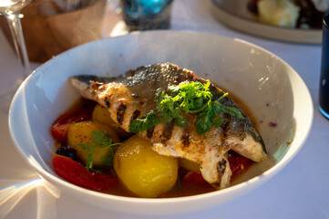 Provence cuisine, filet of seabass white fish served with potatoes, tomatoes and .Bouillabaisse jus in French restaurant