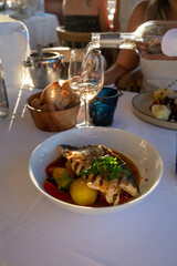 Provence cuisine, filet of seabass white fish served with potatoes, tomatoes and .Bouillabaisse jus in French restaurant