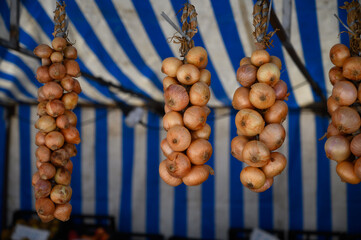 Fresh yellow onion on farmers market with seasonal local vegetables and fruits in small Portuguese...