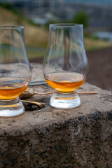 Tasting of single malt scotch whisky in glasses with view from Calton hill to new and old parts of Edinburgh city in rainy day, Scotland, UK