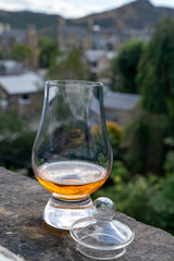 Glass of single malt scotch whisky served on old window sill in Scottisch house with view on old part of Edinburgh, Scotland, UK