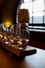 Flight of single malt scotch whisky in glasses served in whiskey bar in Edinburgh, UK