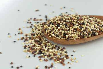 quinoa seed mix in a wooden spoon on white background isolated