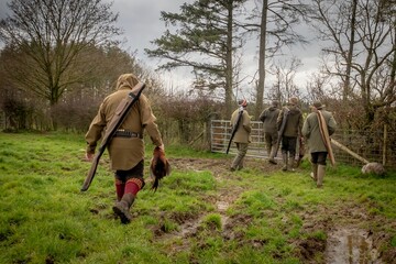 Beautiful view of hunters walking on the forest road on a cloudy day