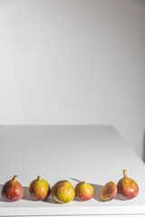 Figs whole and halves in a white rectangular porcelain plate on a cutting board ready for breakfast. Place for text