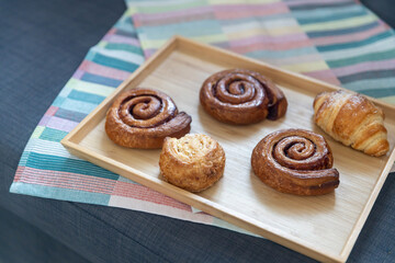 Homemade cinnamon buns with spices and caramel on parchment paper.