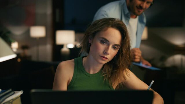 Freelance lady writing text at evening closeup. Man peeping screen distracting