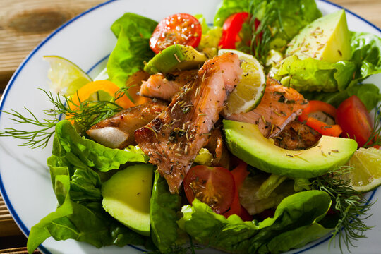 Image of delicious salad of fried trout, avocado, tomatoes and herbs
