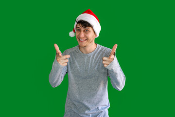 Smiling young man with christmas hat pointing to the front. concept person at christmas.