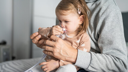 one child toddler girl using steam inhaler nebulizer at home