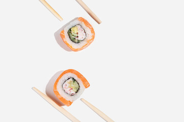 Three Japanese sushi with salmon, dragon rolls on a pastel yellow background. Pop art.