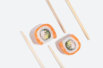 Three Japanese sushi with salmon, dragon rolls on a pastel yellow background. Pop art.