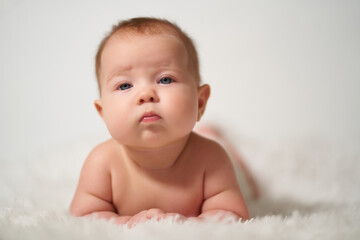 portrait of an infant with nonchalant haughty emotion on a white background