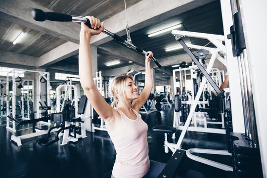 Sport woman exercise strength pulldown in fitness gym
