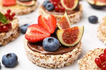 Tasty crispbreads with chocolate, figs and sweet berries on light table, closeup