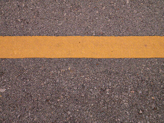 Fototapeta premium The asphalt and yellow line flat lay image for background or texture concept
