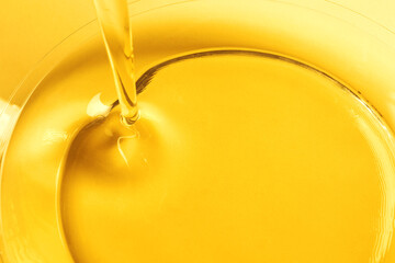 Pouring cooking oil into glass bowl, closeup