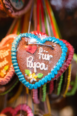 Traditional Gingerbread heart cookie (Lebkuchenherz) with sugar icing as gift for father at Christkindlesmarkt Nürnberg, famous Christmas market, saying 'für Papa', German 'for Daddy' - 550155328