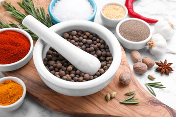 Mortar and spices on white marble table, closeup