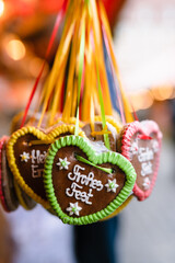 Traditional Gingerbread heart cookie (Lebkuchenherz) with sugar icing at Christkindlesmarkt Nürnberg, famous Christmas market, saying Frohes Fest, German for Merry Christmas or Season's Greetings - 550155343