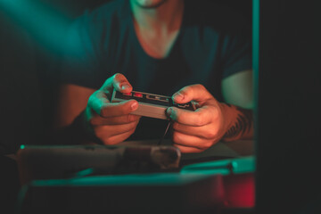 A close up of a retro console and retro controllers in retro 80s environment with colors at night...