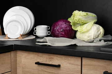 Different types of cabbage on countertop in kitchen