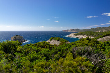 Corsica landscape with white rocks and green mountains and blue sky