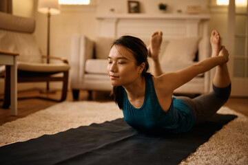 Young Asian woman stretching on floor during home workout.