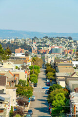 Aerial shot of main parkway or road in San Francisco California with suburban and urban scene midday in sun with moutains and sky