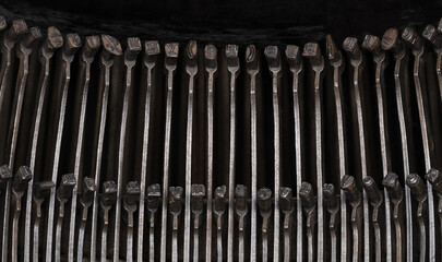 Type bars of an antique typewriter closeup view from above