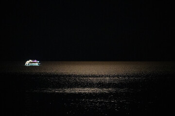 The ship goes to sea on a summer night in the rays of the full moon