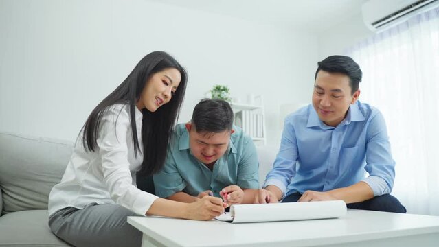 Asian happy family draw picture with young son in living room at home