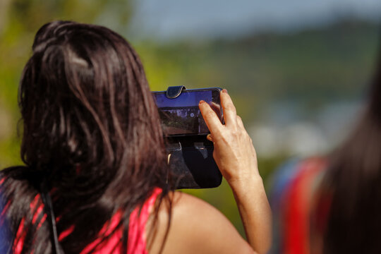 Woman takes a picture of the Iguazu Falls