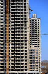 Crane and building construction site against blue sky 