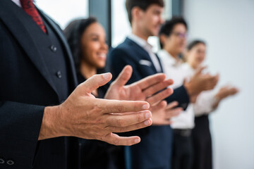 Close up hand of young businessman and businesswoman clapping together.