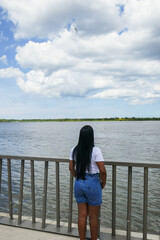 Woman on the promenade and the Magdalena river. Barranquilla, Colombia