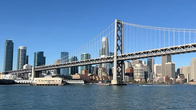 4K HD video coming into Downtown San Francisco on the water, under the bay bridge then approaching the financial district from the water, clear blue sky above.
