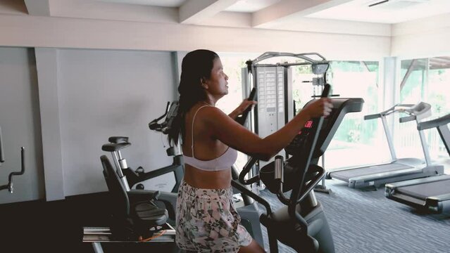 Close Up Of A Thai Fitness Young Woman In Sports Clothing Exercising On Cardio Machine At Gym , Asian Mature Women Mid Age Fitness Indoors In The Gym