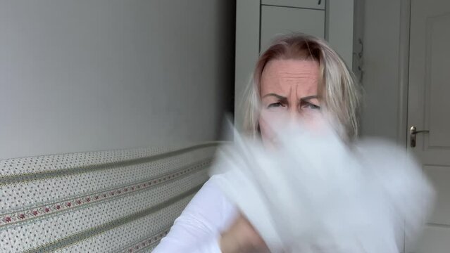 Allergy cold runny nose woman gets a lot napkins Looks unhappy in the camera slow motion At the end waving napkins Wipe nose