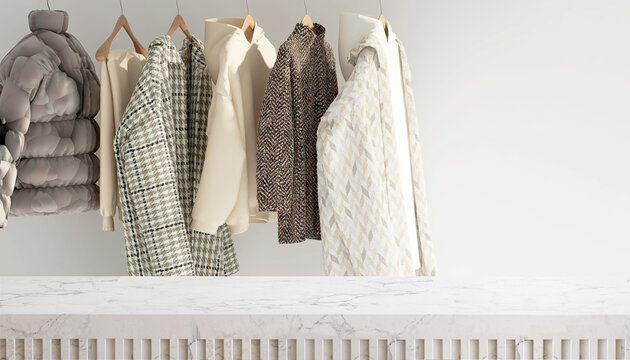 Modern and minimal white marble table top or countertop with winter collection of clothes, fleece, sweater, jackets and coat in with sunlight from window for product display - Powered by Adobe