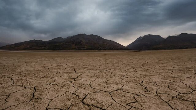 cracked landscape dry lake or river Timelapse with Dramatic gloomy cloud, lack of freshwater global warming climate change concept, Cracked soil Cinematic Timelapse of desert dry land , ecological