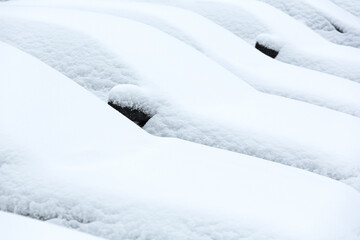 cars on parking lot are covered with a thick layer of snow. winter city scenery.