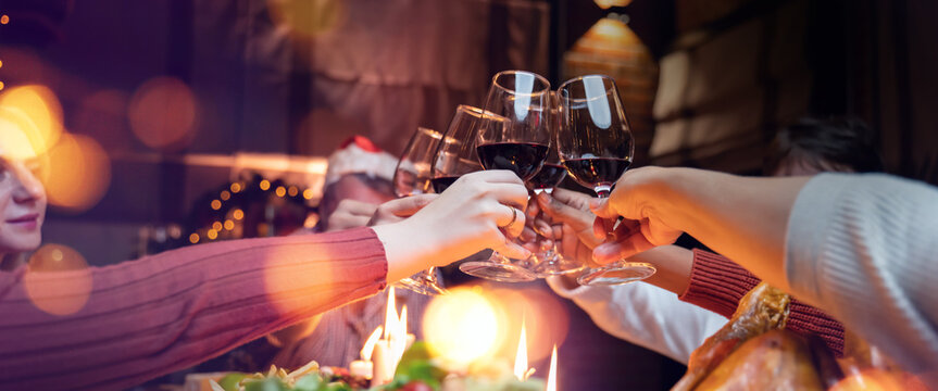 christmas party 2022,holidays and celebration concept - happy big family and friends having christmas dinner at home,drinking red wine in christmas and new year party of American family at home.