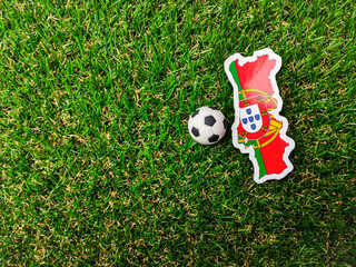 A ball and Portugal flag sticker is on a green field.