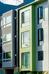Row of vertical town homes in San Francisco California with modern decorative house facades green and gray