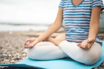 Fototapeta na wymiar Closeup female yoga hands mudra fingers connected lotus position meditation on beach peace of mind