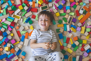 Wooden bricks Montessori material rainbow spectrum. Little cute boy plays with cubes.
