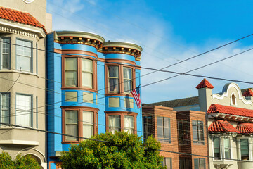 Obraz premium Row of decorative colorful houses with visible powerlines and modern home facades in San Francisco California