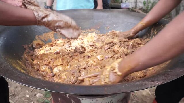 The process of stirring using meat hands to cook Acehnese curry