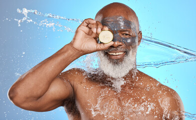 Fototapeta na wymiar Face, water splash and senior black man with lemon and clay mask in studio isolated on a blue background. Portrait, cleaning and hygiene of elderly male model with fruit for nutrition and vitamin c.